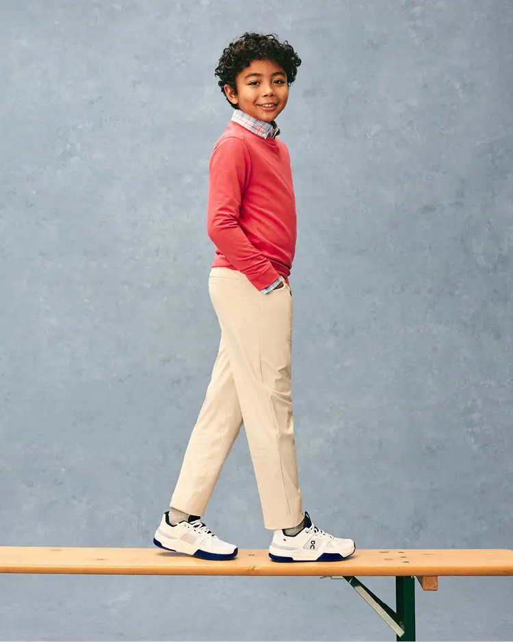 Boy wearing a red sweatshirt and khaki pants at school